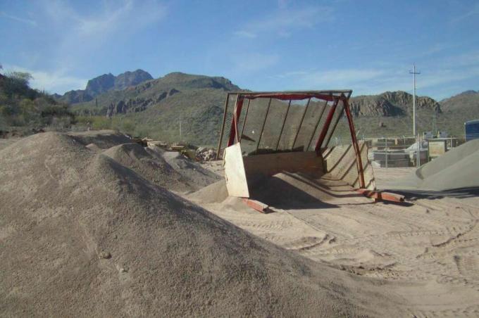 vinklade skärmar fästa på metallstolpar som är placerade i sandhögar