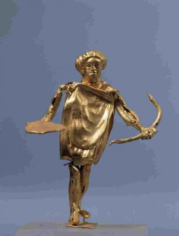 Guld- staty av Apollo med pilbågen på skärm i grekiskt konstmuseum.