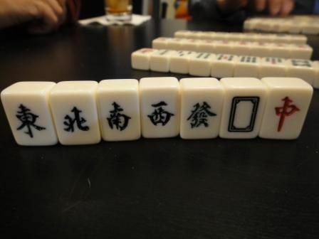 Vindarna och drakar kakel i en Mahjong-uppsättning som står upprätt på ett bord.