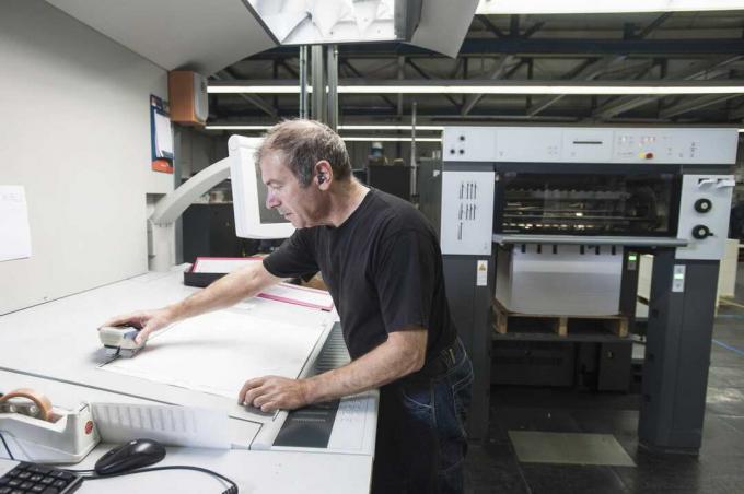 Arbetare som förbereder digital tryckutrustning i tryckseminarium