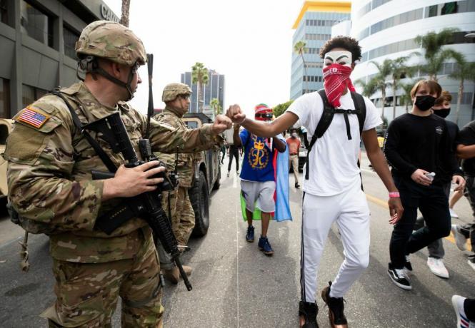 En demonstrant knytnäve stöter på en medlem av National Guard under en marsch som svar på George Floyds död den 2 juni 2020 i Los Angeles, Kalifornien.