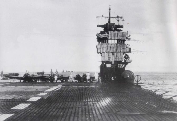 Flygdäck Akagi med ön till höger och flygplan parkerat på däck.