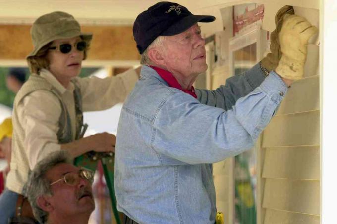 USA: s tidigare president Jimmy Carter och hans fru Rosalyn fäster ytterkant på framsidan av ett hem för livsmiljö som byggs den 10 juni 2003 i LaGrange, Georgien.