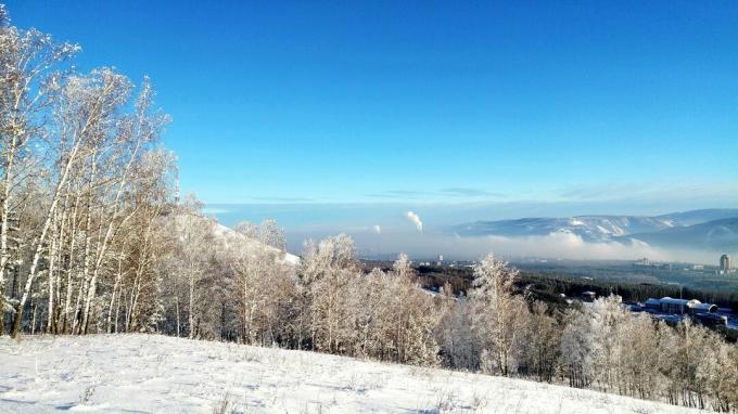 Scenisk sikt av snö täckt landskap mot blå himmel