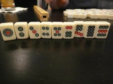 Stendräkten av en standarduppsättning Mahjong-plattor som står upp på ett bord.