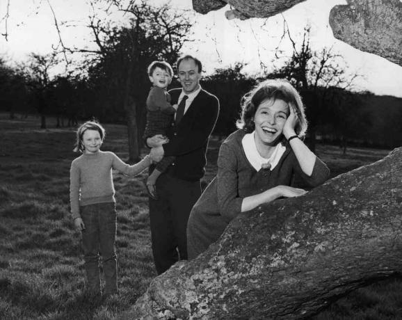 Svartvitt foto av Roald Dahl som håller sina barn; hans fru Patricia Neal lutar sig på ett träd