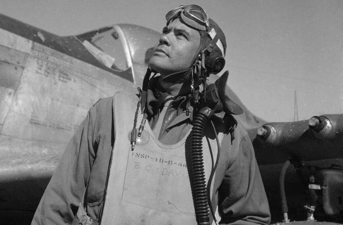 Benjamin O. Davis i en flygdräkt och hjälm som står framför en P-51 Mustang-fighter.