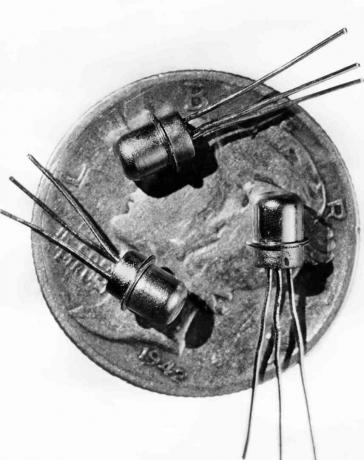 Bild daterad 1956 av tre miniatyr M-1-transistorer sett på en krona