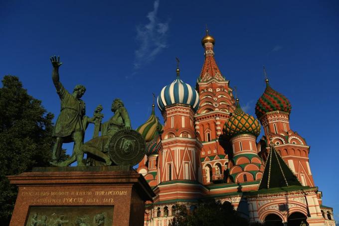 Ljusfärgad, lök-kupolad St. Basil's Cathedral med staty framför