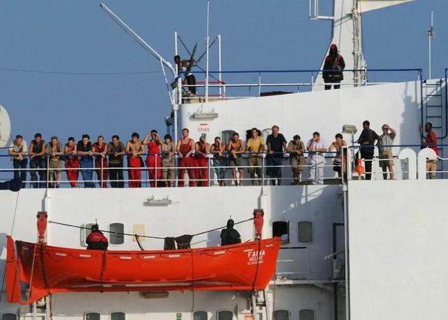 Somaliska pirater som håller i handelsfartyget, MV Faina, står på fartygets däck med besättningsmedlemmar den 19 oktober 2008.