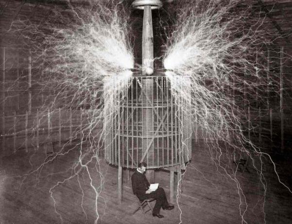 Nikola Tesla sitter i sitt laboratorium i Colorado Springs bredvid sin enorma 