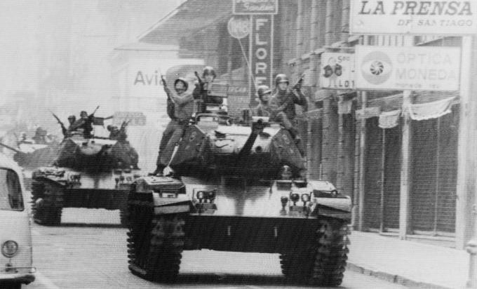 Soldater rider ovanpå stridsvagnar på gatorna i Santiago, Chile, då armégeneral Augusto Pinochet svurs in som president.