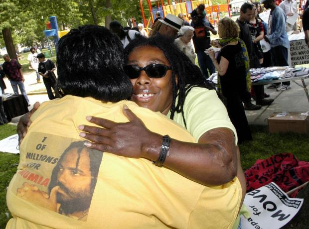 Ramona Africa (R), den ensamma överlevaren från MOVE-tragedin 1985, kramar Denise Garner (L) under en minnesmarsj 2005