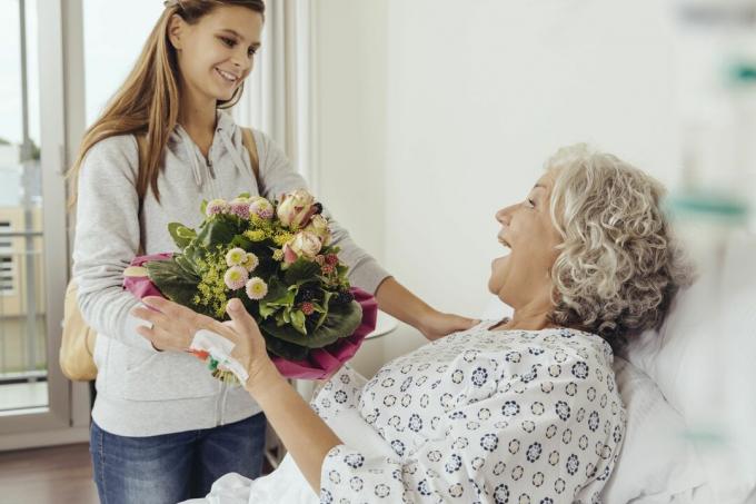 Barnbarn besöker mormor på sjukhus och tar med sig blommor